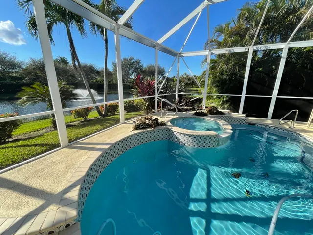 a view of a swimming pool with a patio and a yard
