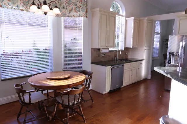 a kitchen with stainless steel appliances a dining table chairs and a stove