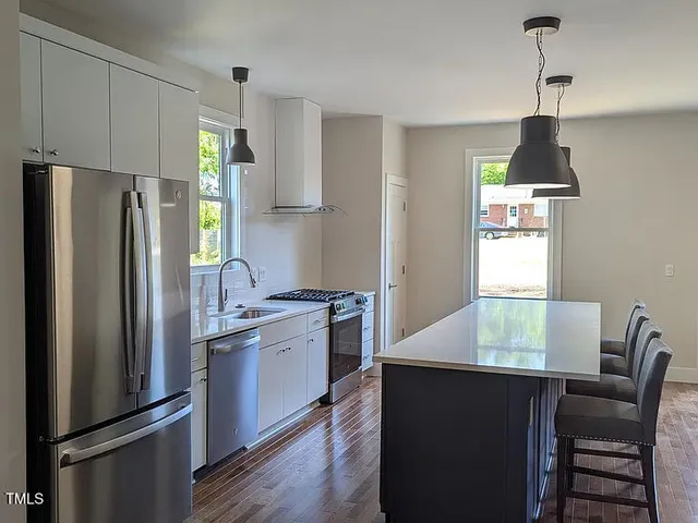 a large white kitchen with a large window