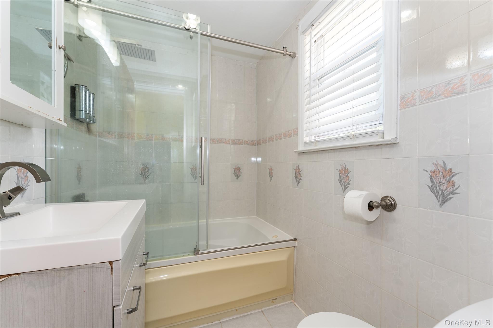 7 Mayfair Road Baldwin, NY 11510 - Photo 16 of 27 a bathroom with a shower sink and mirror