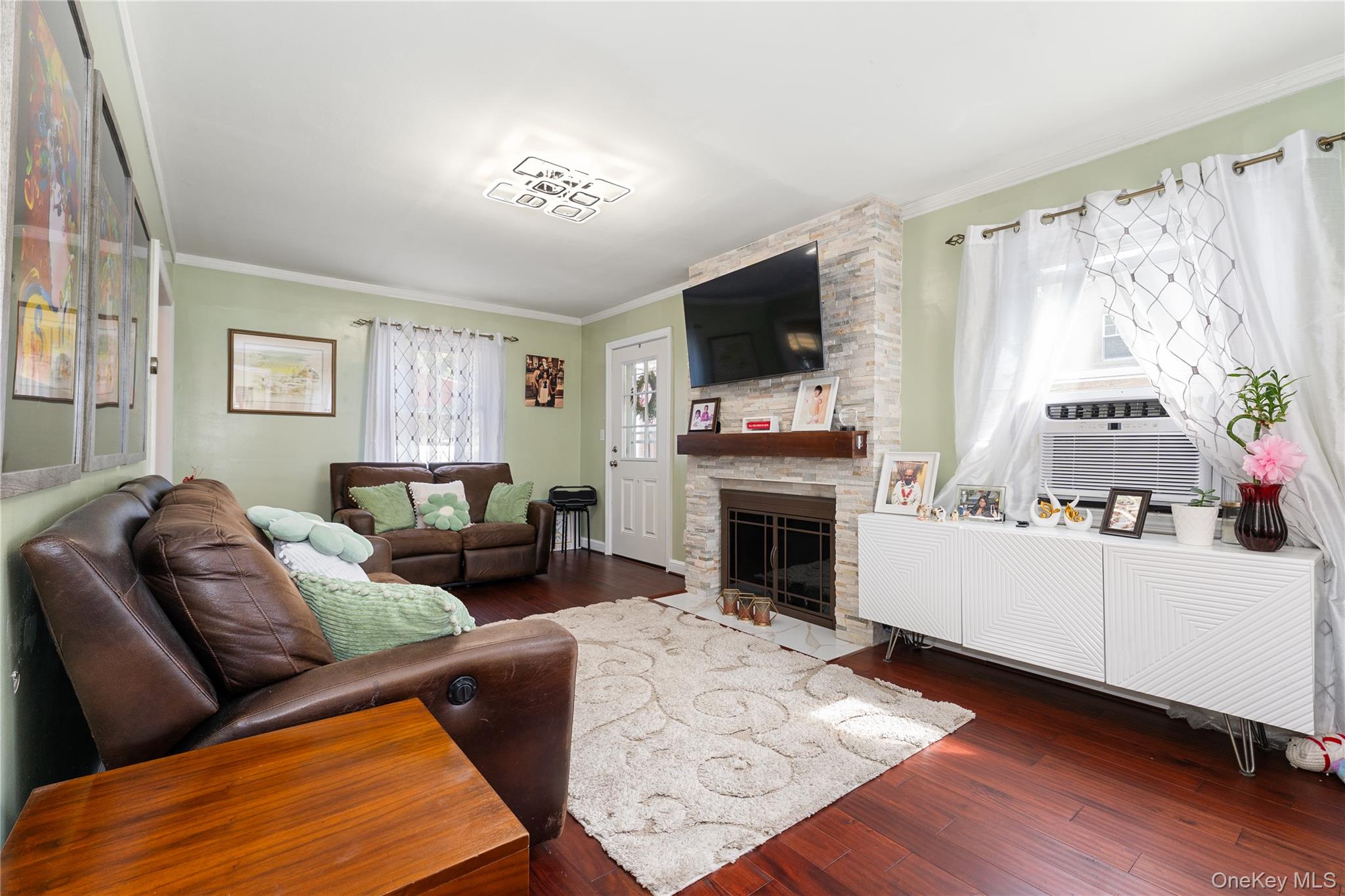7 Mayfair Road Baldwin, NY 11510 - Photo 4 of 27 a living room with furniture a flat screen tv and a fireplace