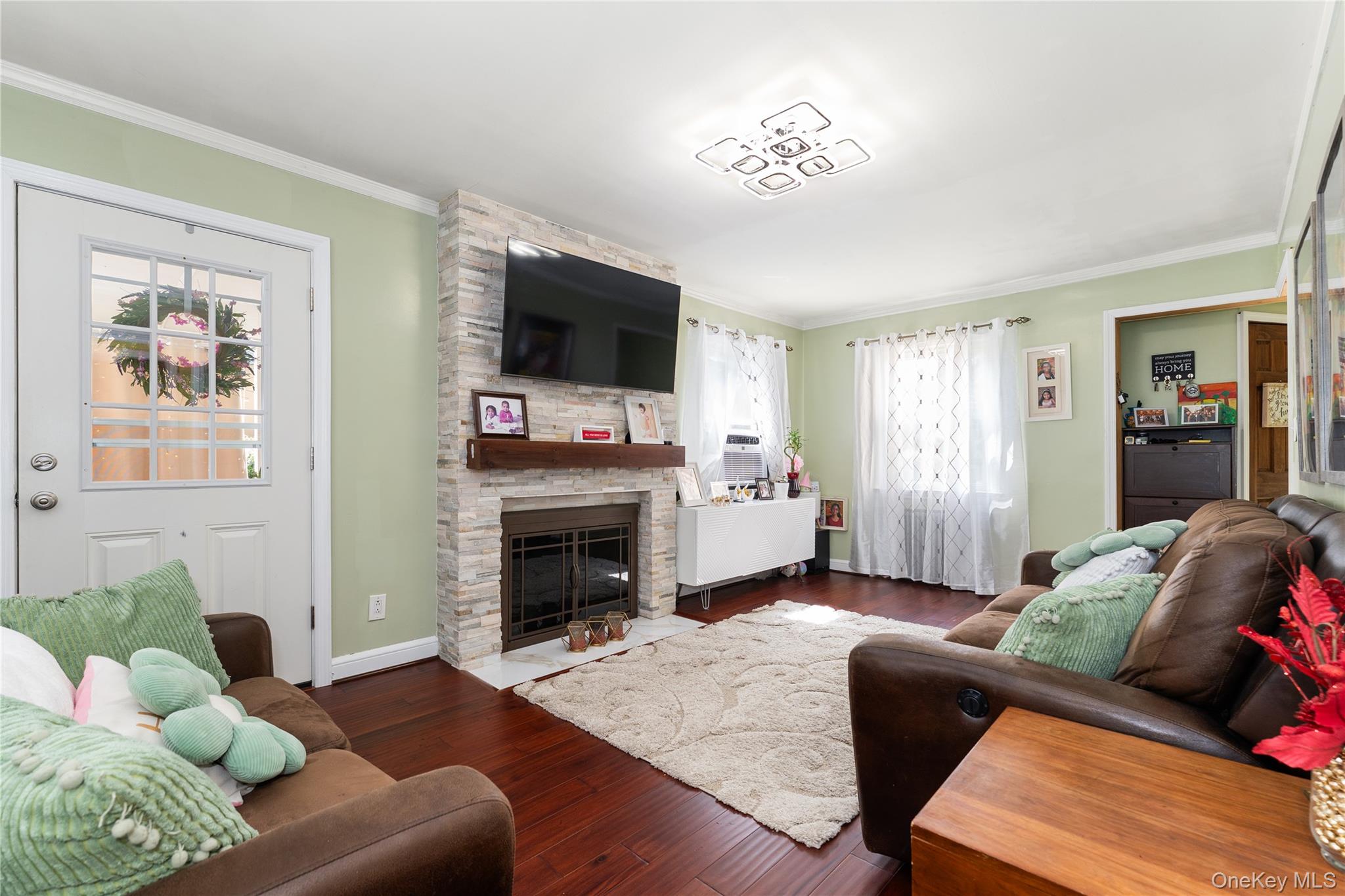 7 Mayfair Road Baldwin, NY 11510 - Photo 5 of 27 a living room with furniture a flat screen tv and a fireplace