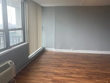 a view of a room with wooden floor and window