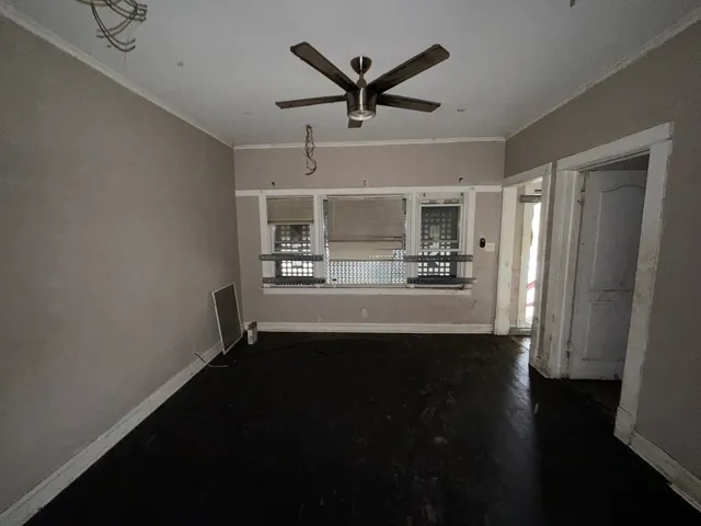 a view of a livingroom with a ceiling fan wooden floor and a ceiling fan