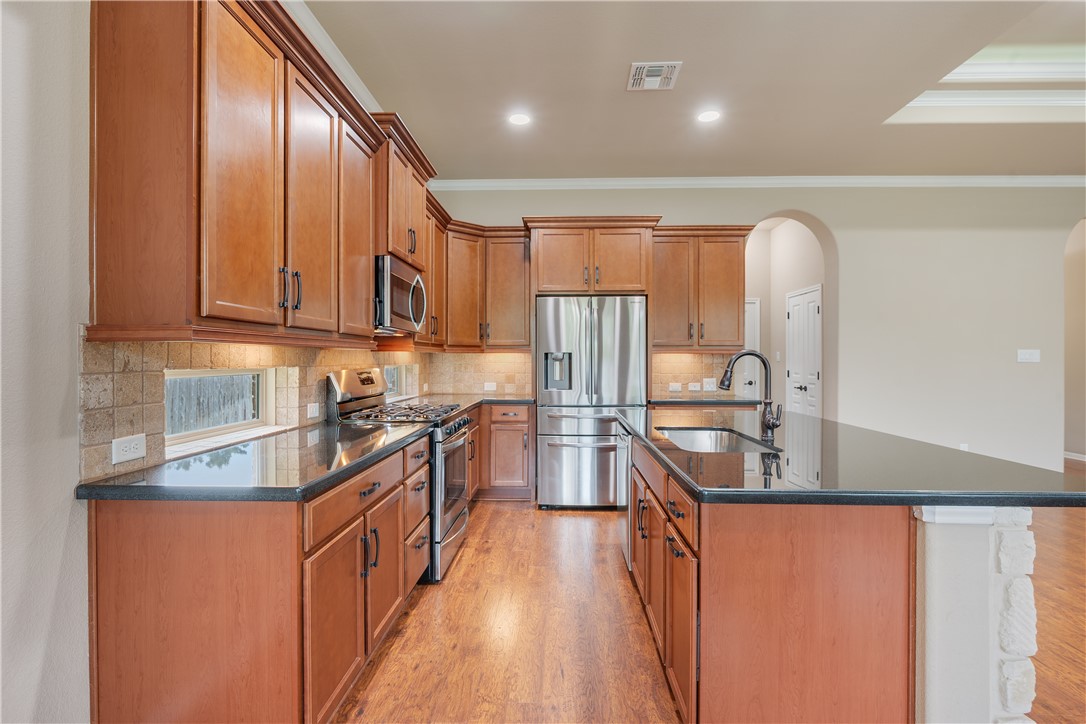 3085 Archer Circle Bryan, TX 77808 - Photo 6 of 31 a kitchen with stainless steel appliances granite countertop a sink stove and refrigerator