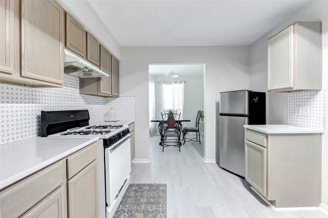 a kitchen with stainless steel appliances a stove a sink and a refrigerator