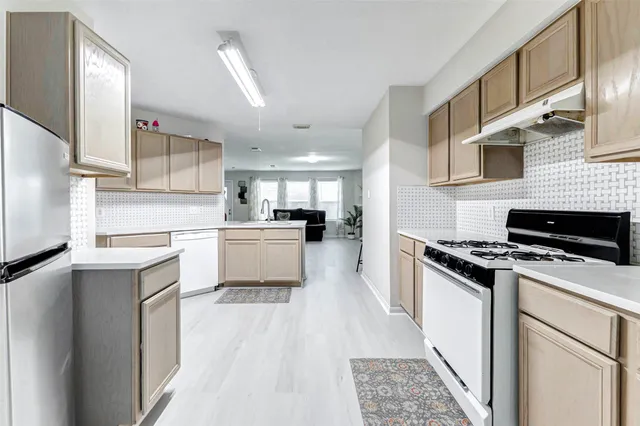 a kitchen with white cabinets and appliances