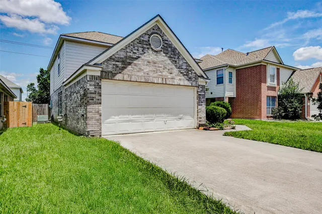 a view of a house with a yard and garage