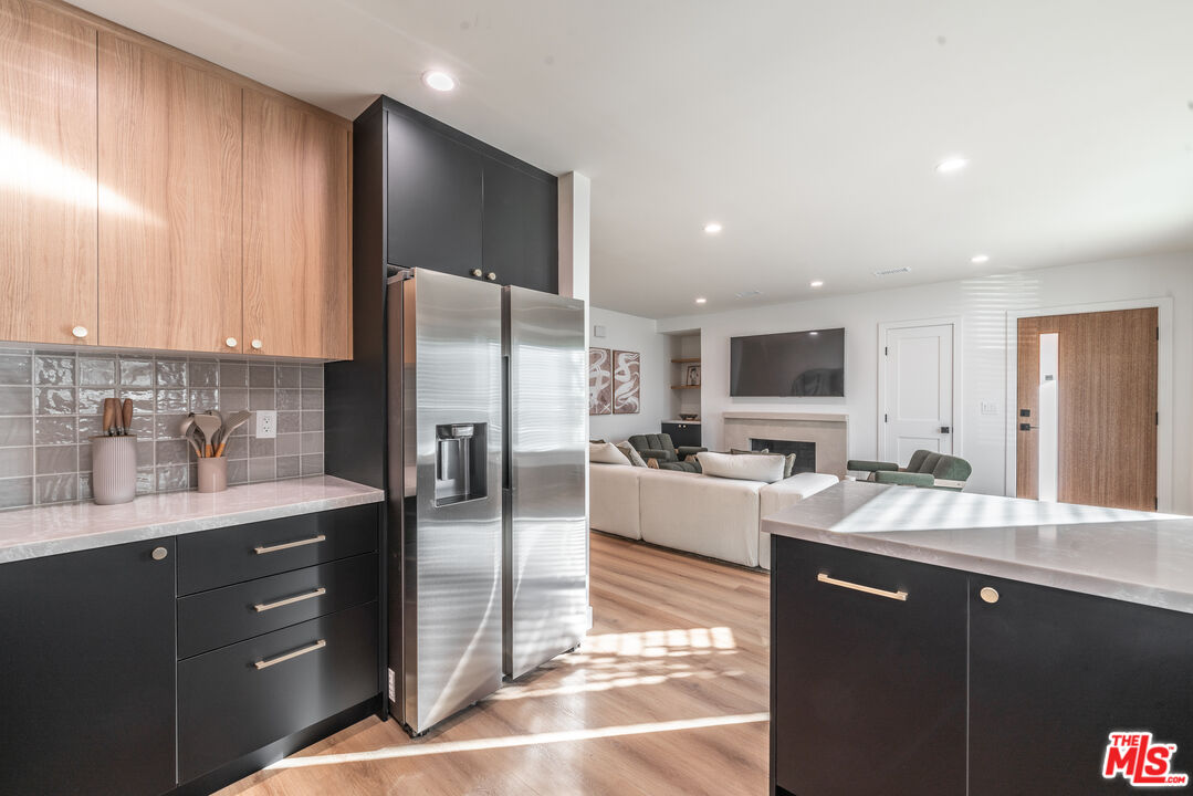 Undisclosed Address Los Angeles, CA 90008 - Photo 16 of 28 a open kitchen with stainless steel appliances granite countertop a refrigerator a sink dishwasher a stove and white cabinets with wooden floor