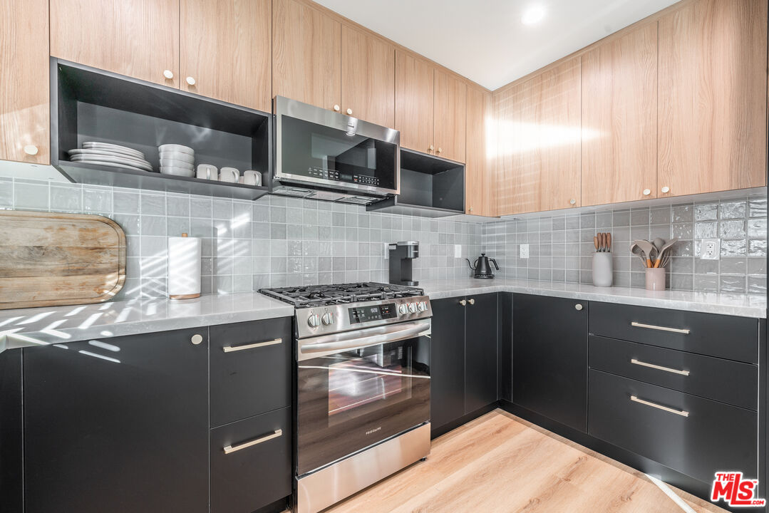 Undisclosed Address Los Angeles, CA 90008 - Photo 20 of 28 a kitchen with stainless steel appliances granite countertop a stove a sink and a microwave
