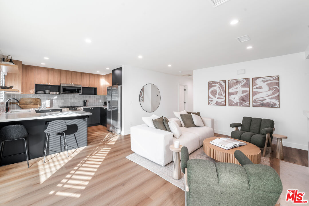 Undisclosed Address Los Angeles, CA 90008 - Photo 2 of 28 a living room with fireplace furniture and a kitchen view