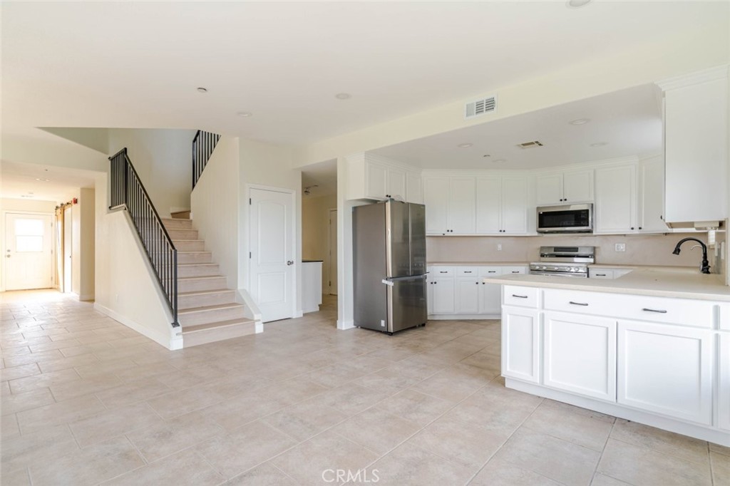 2575 Rale Drive Palmdale, CA 93550 - Photo 9 of 41 a kitchen with stainless steel appliances a refrigerator and a sink