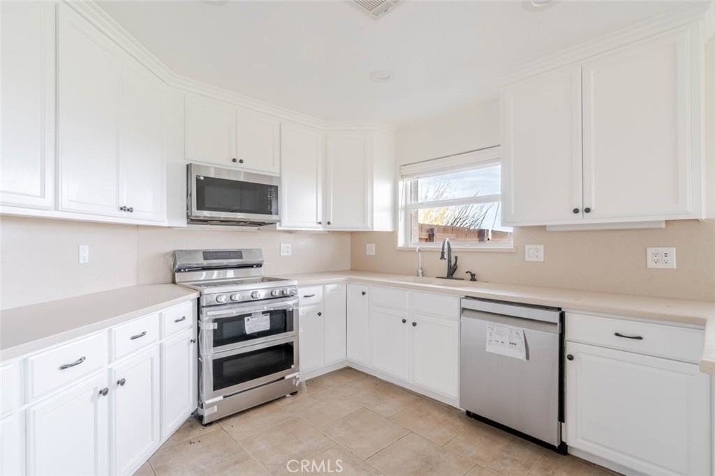 2575 Rale Drive Palmdale, CA 93550 - Photo 10 of 41 a kitchen with white cabinets appliances and sink