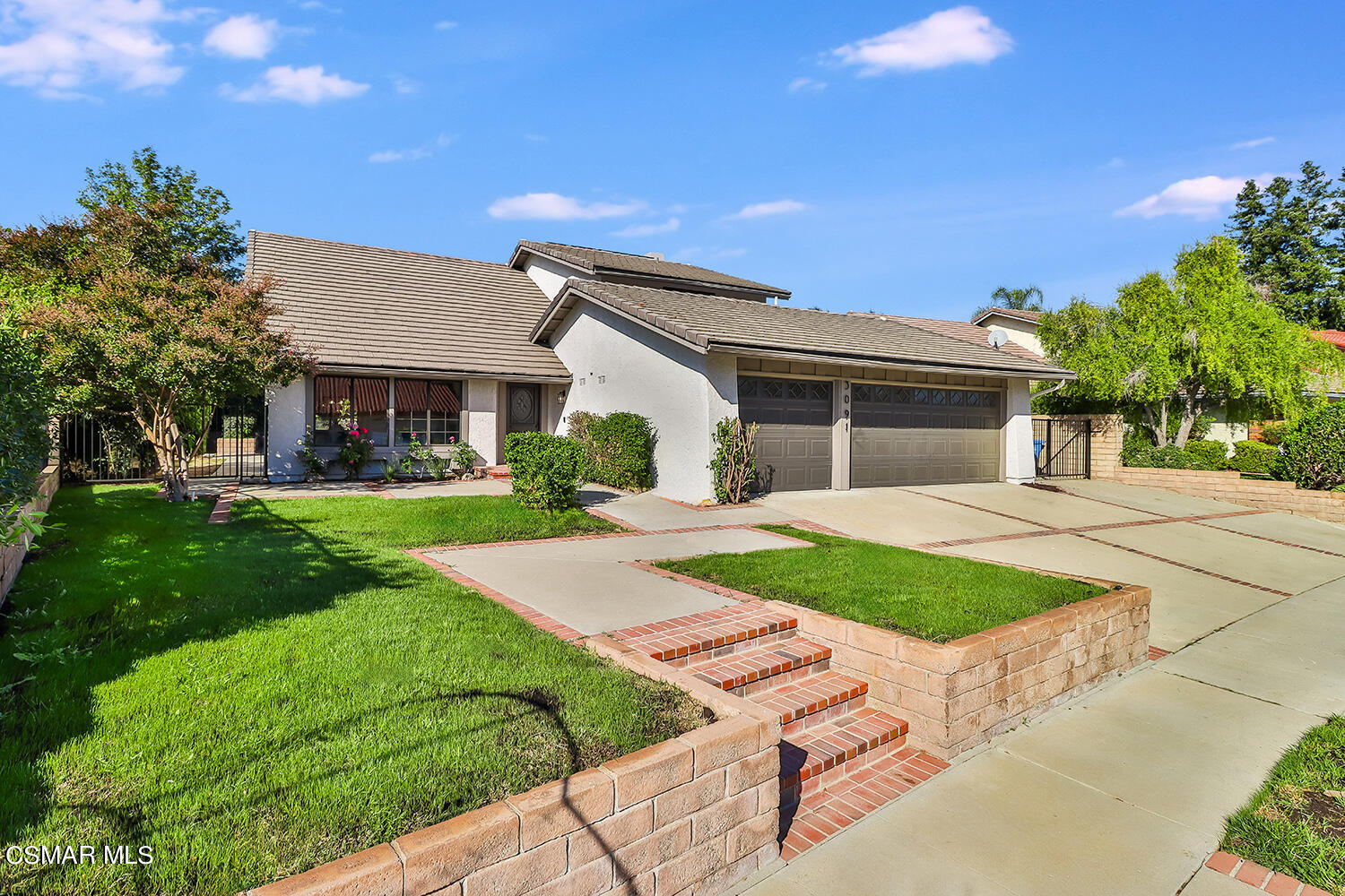 a front view of a house with a yard and potted plants