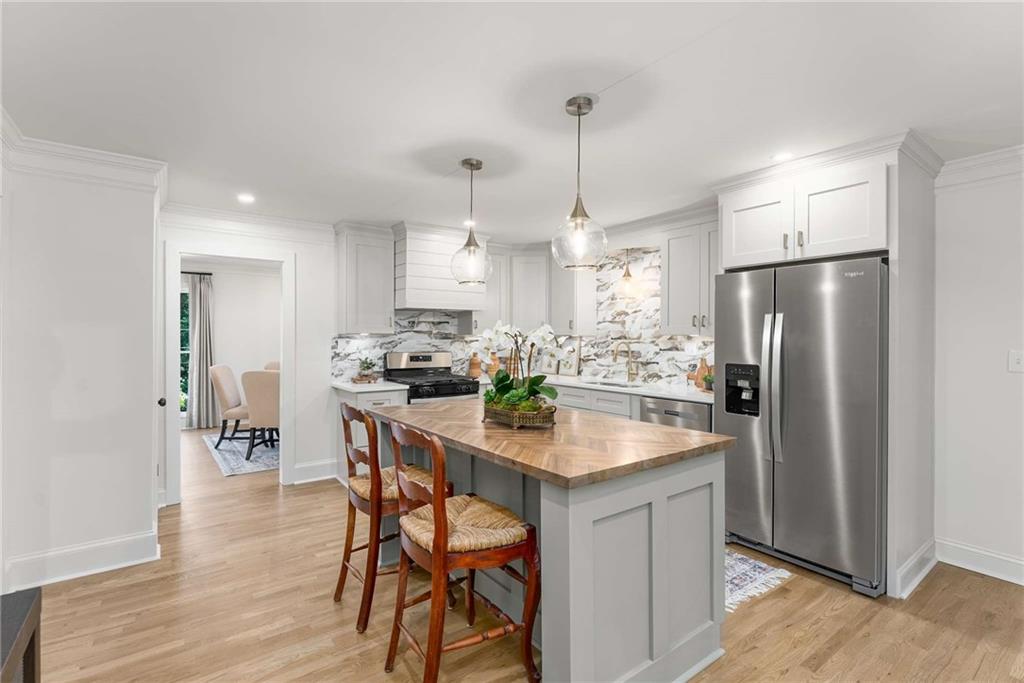 3549 Castlehill Court Tucker, GA 30084 - Photo 10 of 41 a kitchen with stainless steel appliances a dining table chairs refrigerator and cabinets