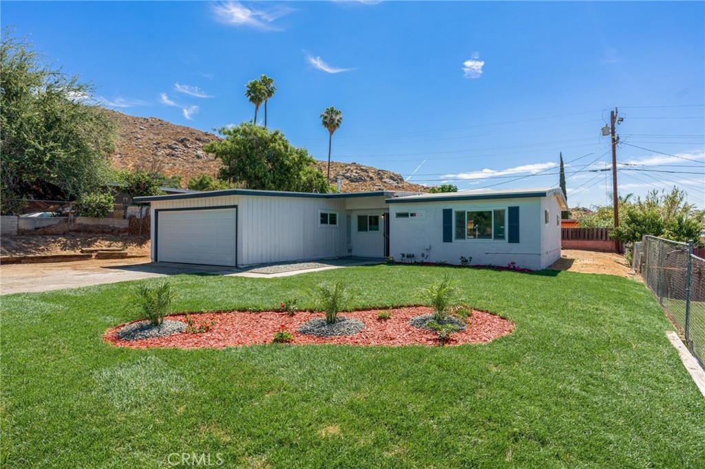 a front view of a house with a garden and yard