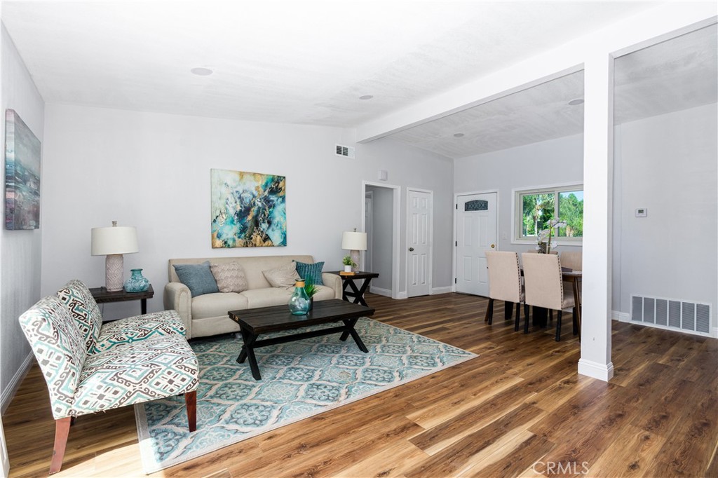 3254 Laurel Drive Riverside, CA 92509 - Photo 6 of 26 a living room with couches couches and a dining table with wooden floor