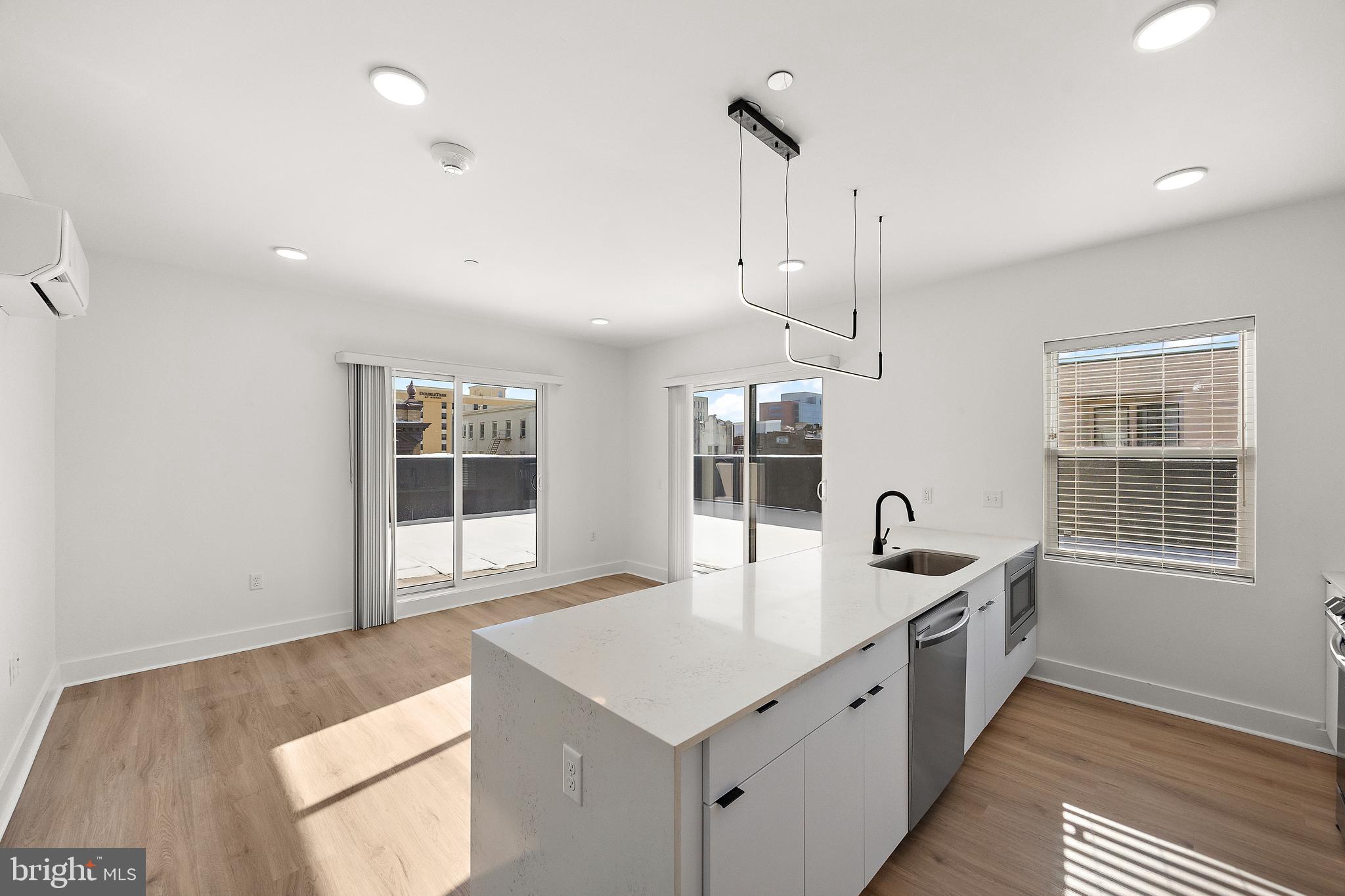 801 North Market Street, Unit 305 Wilmington, DE 19801 - Photo 1 of 11 a large white kitchen with a sink a window and stainless steel appliances