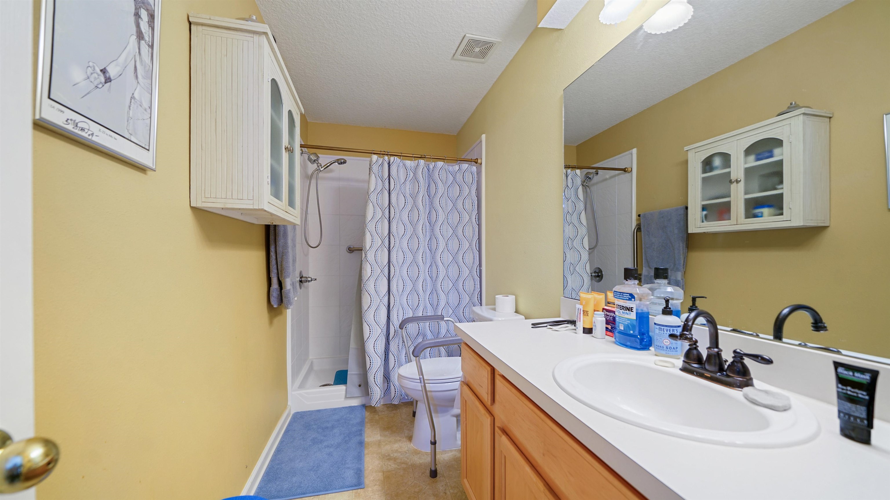 875 Scrub Jay Drive St. Augustine, FL 32092 - Photo 12 of 28 a bathroom with a sink a mirror and a shower