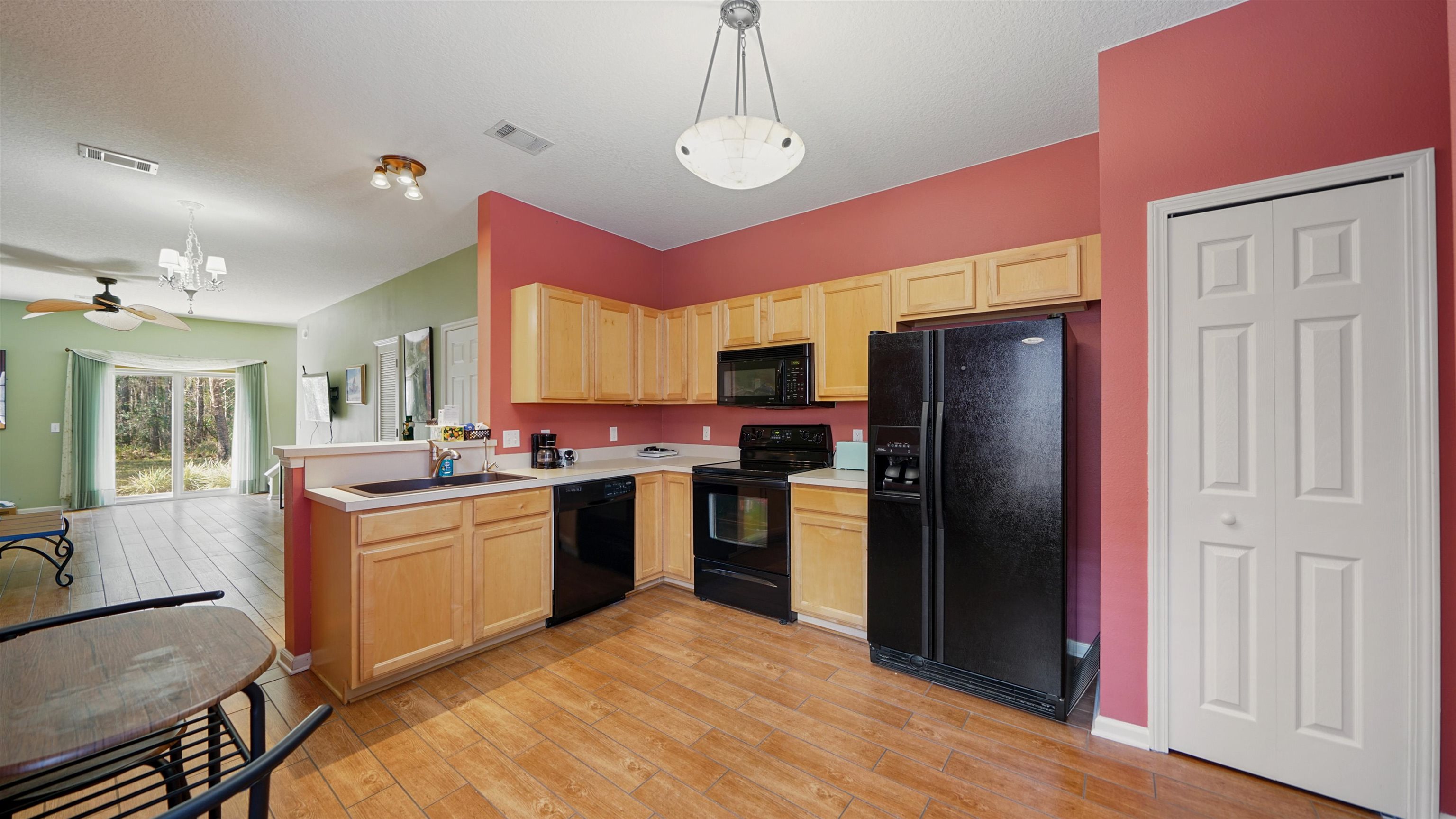 875 Scrub Jay Drive St. Augustine, FL 32092 - Photo 4 of 28 a kitchen with refrigerator a stove and wooden floor