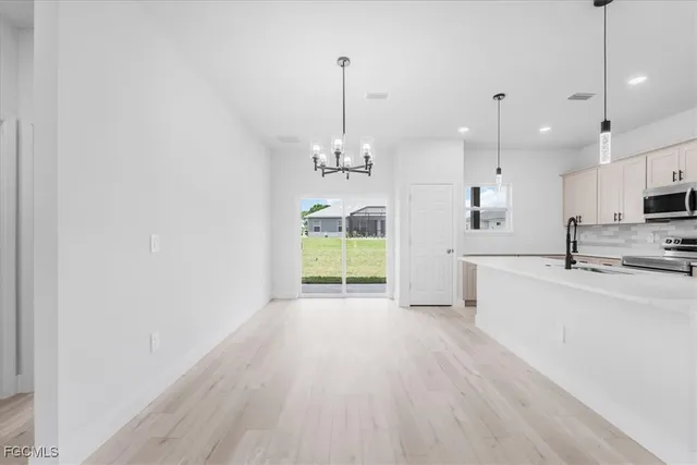 a large kitchen with granite countertop a stove a sink dishwasher and a wooden floor