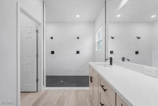 a bathroom with a sink a large mirror and shower