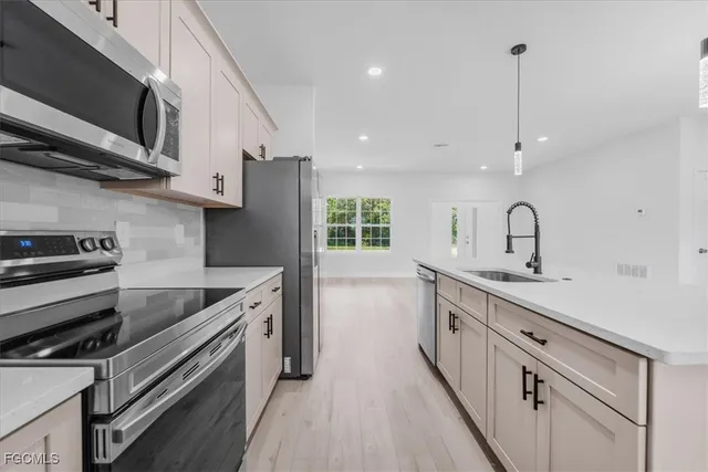 a kitchen with stainless steel appliances a sink stove and cabinets