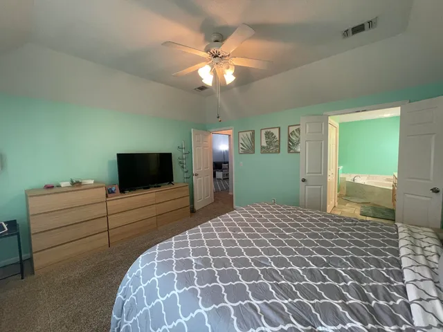 a bedroom with a large bed and a flat screen tv