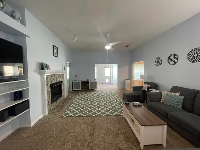 a living room with furniture fireplace and flat screen tv