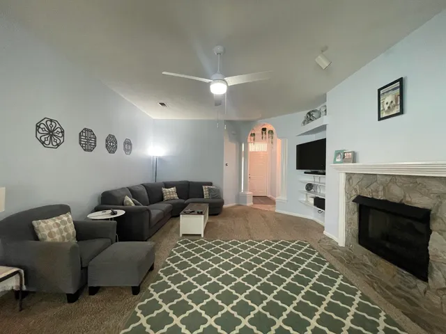 a living room with furniture a fireplace and a flat screen tv