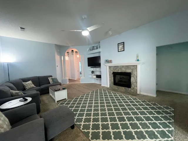 a living room with furniture a flat screen tv and a fireplace