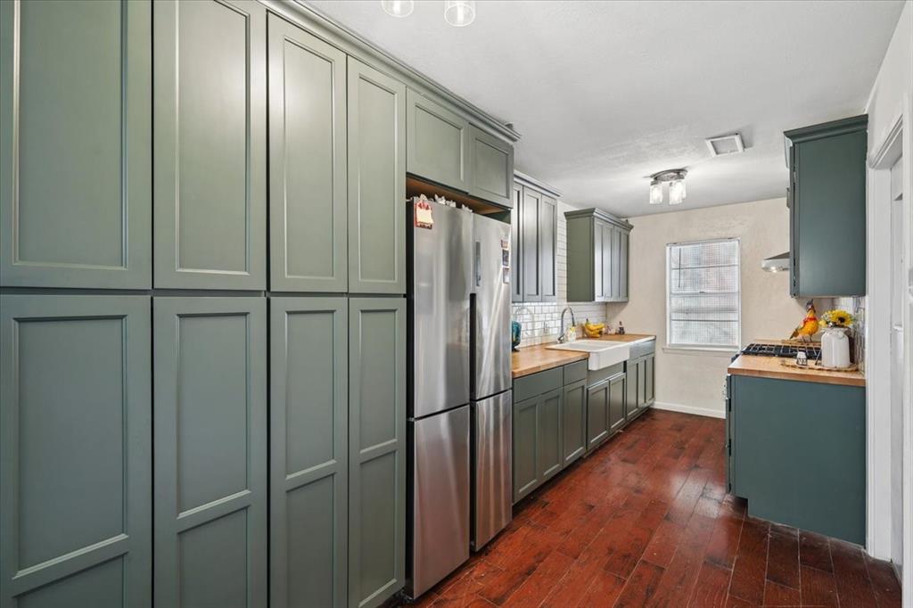 2508 West Rochelle Road Irving, TX 75062 - Photo 4 of 19 a kitchen with stainless steel appliances granite countertop a refrigerator a sink dishwasher a stove and a dining table with wooden floor