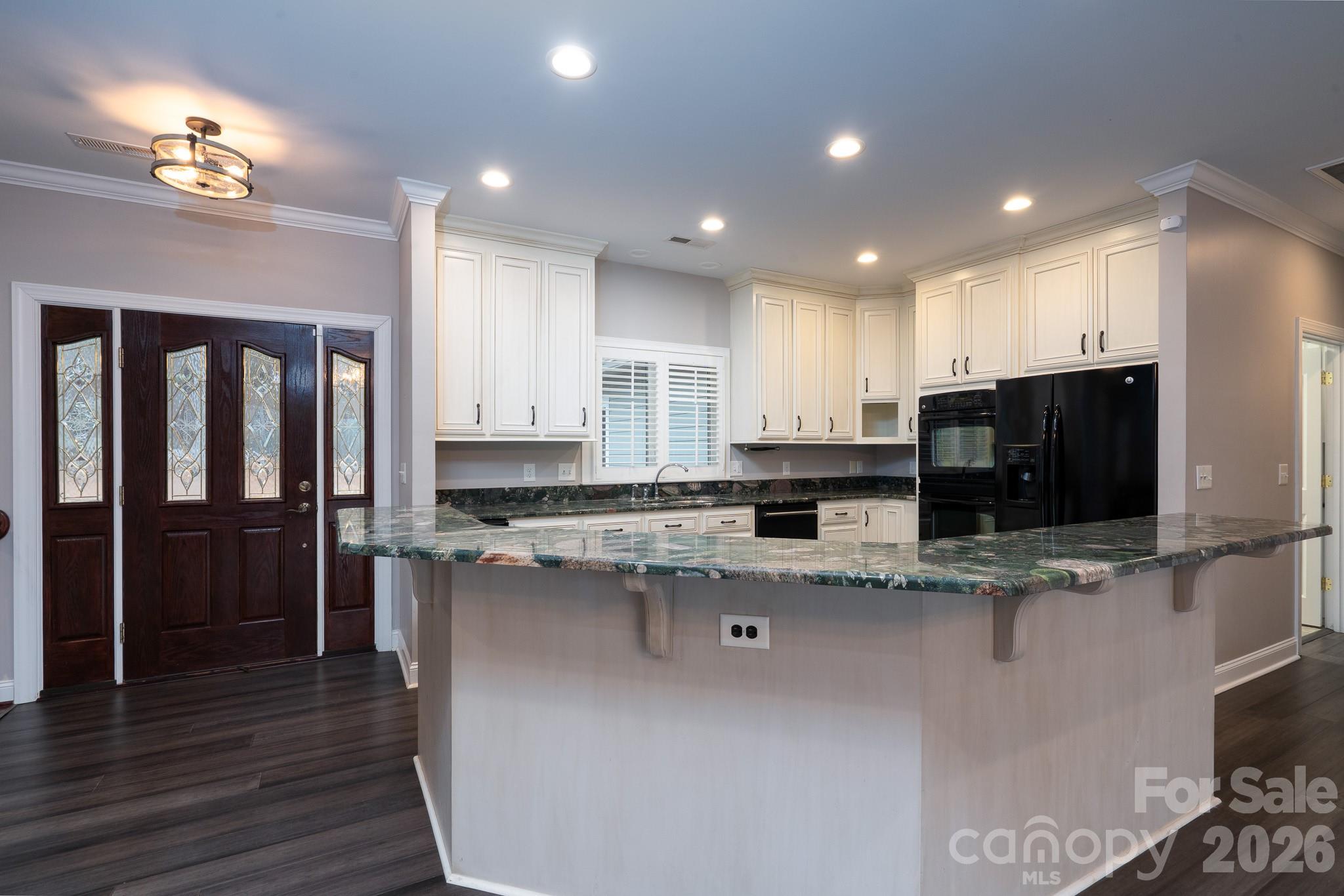 338 PLANTATION Way Mount Gilead, NC 27306 - Photo 14 of 48 a kitchen with stainless steel appliances granite countertop a stove a sink a refrigerator and a oven with wooden floor