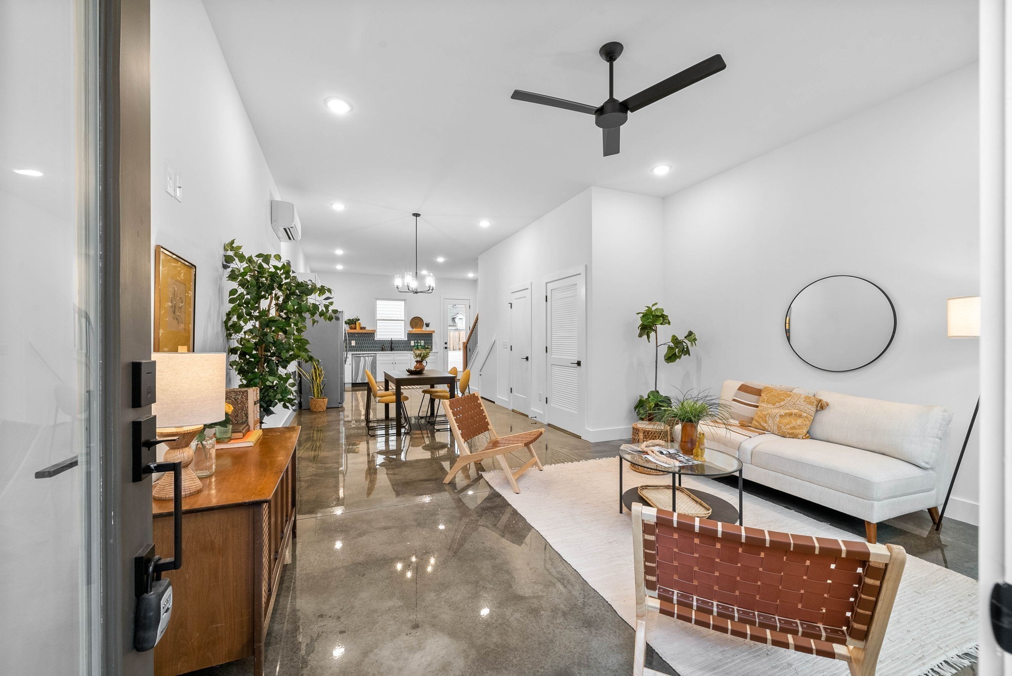 a living room with furniture a chandelier and a dining table