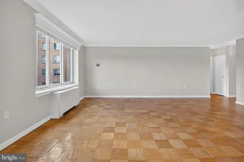 a view of empty room with window and wooden floor