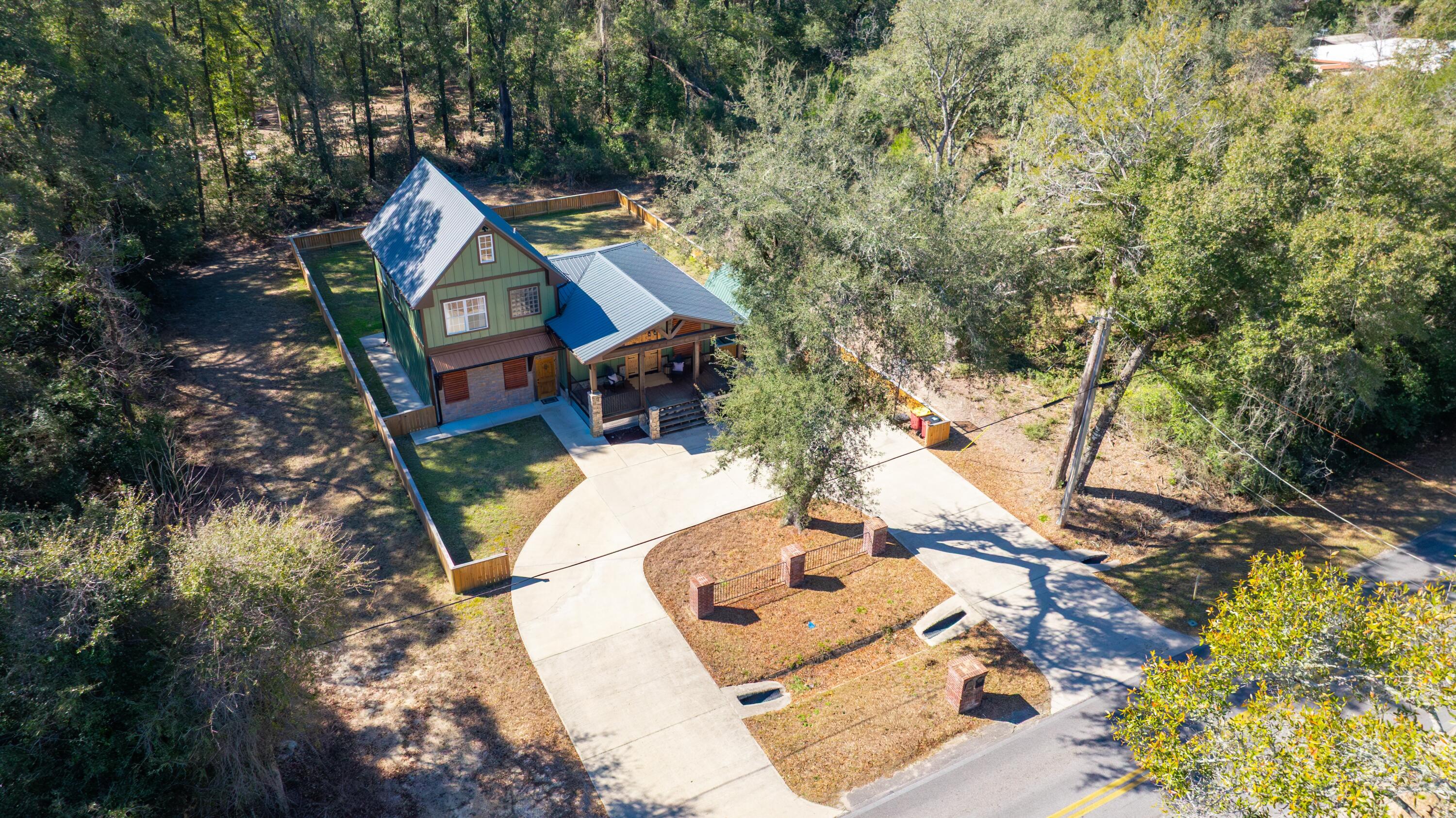 981 East Chestnut Avenue Crestview, FL 32539 - Photo 74 of 80 an aerial view of a house with swimming pool and large trees