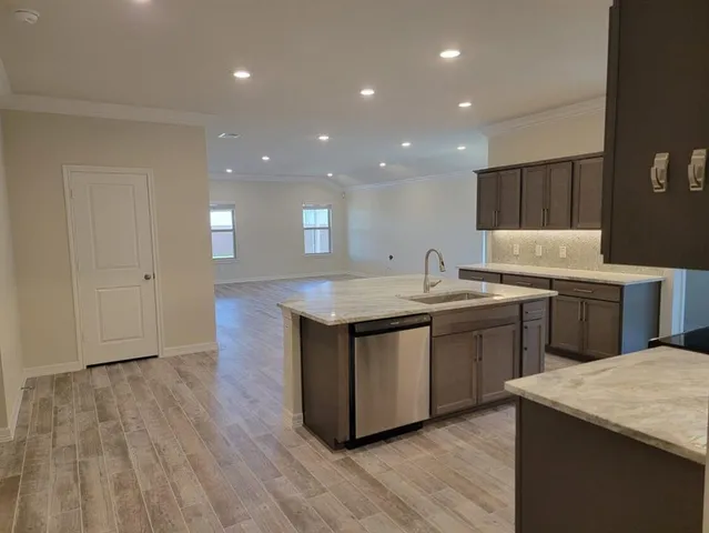 a kitchen with granite countertop a sink and a stove top oven