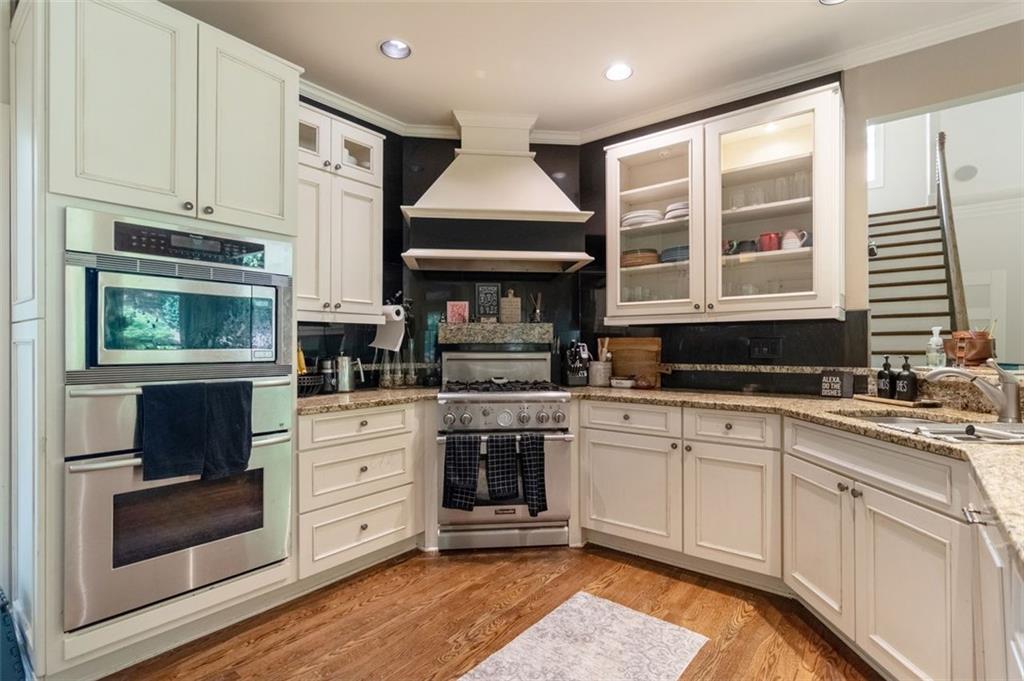 3850 Glenhurst Drive Smyrna, GA 30080 - Photo 11 of 43 a kitchen with stainless steel appliances granite countertop a stove and white cabinets