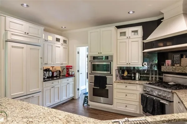 a kitchen with stainless steel appliances kitchen island granite countertop a refrigerator and a stove top oven