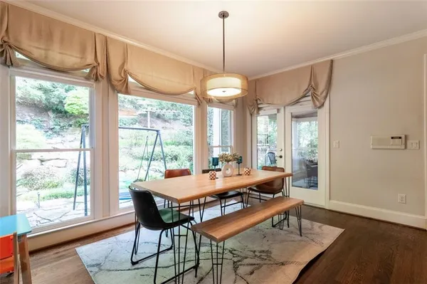 a dining room with wooden floor a chandelier a wooden table and chairs