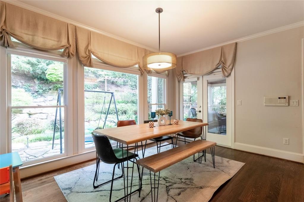 3850 Glenhurst Drive Smyrna, GA 30080 - Photo 15 of 43 a dining room with wooden floor a chandelier a wooden table and chairs