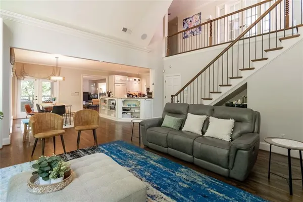 a living room with furniture kitchen view and a wooden floor