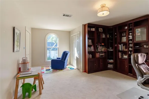 a living room with furniture a bookshelf and a window