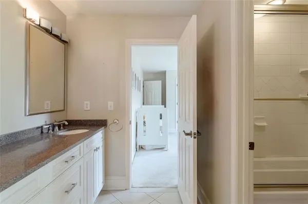 a spacious bathroom with a granite countertop sink and a mirror