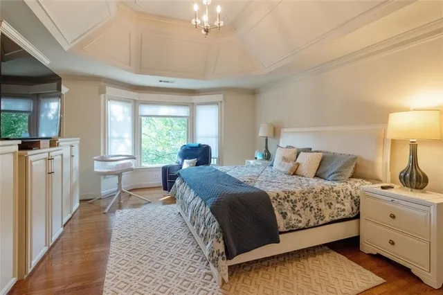 a bedroom with a bed and large windows