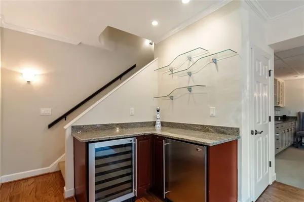 a view of a refrigerator a sink and cabinets in a room