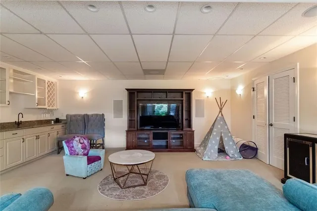 a living room with furniture a flat screen tv and gym equipment