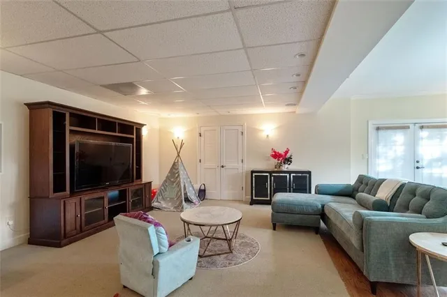a living room with furniture a flat screen tv and a window