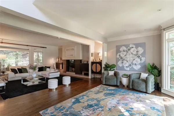 a living room with furniture large window and wooden floor