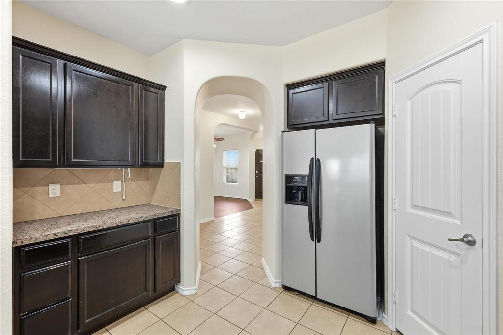720 Rio Bravo Drive Fort Worth, TX 76052 - Photo 18 of 38 Kitchenette featuring dark wood cabinetry, a light-toned patterned countertop, and a tile backsplash